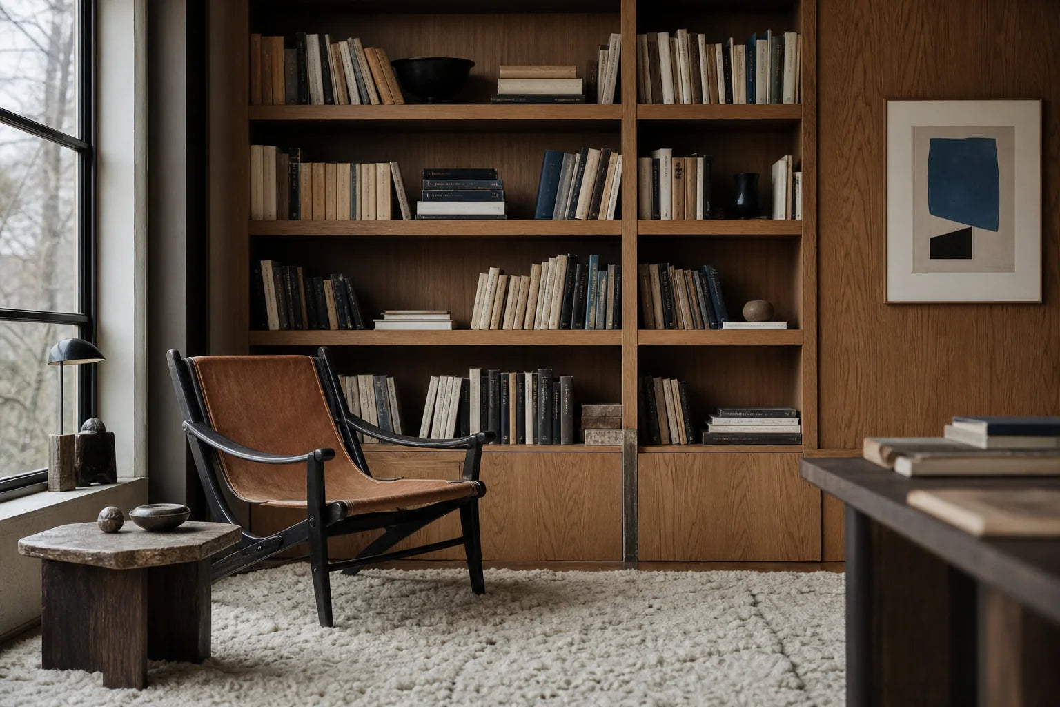 Quiet modernist reading room with vintage lounge chair, books, and abstract art