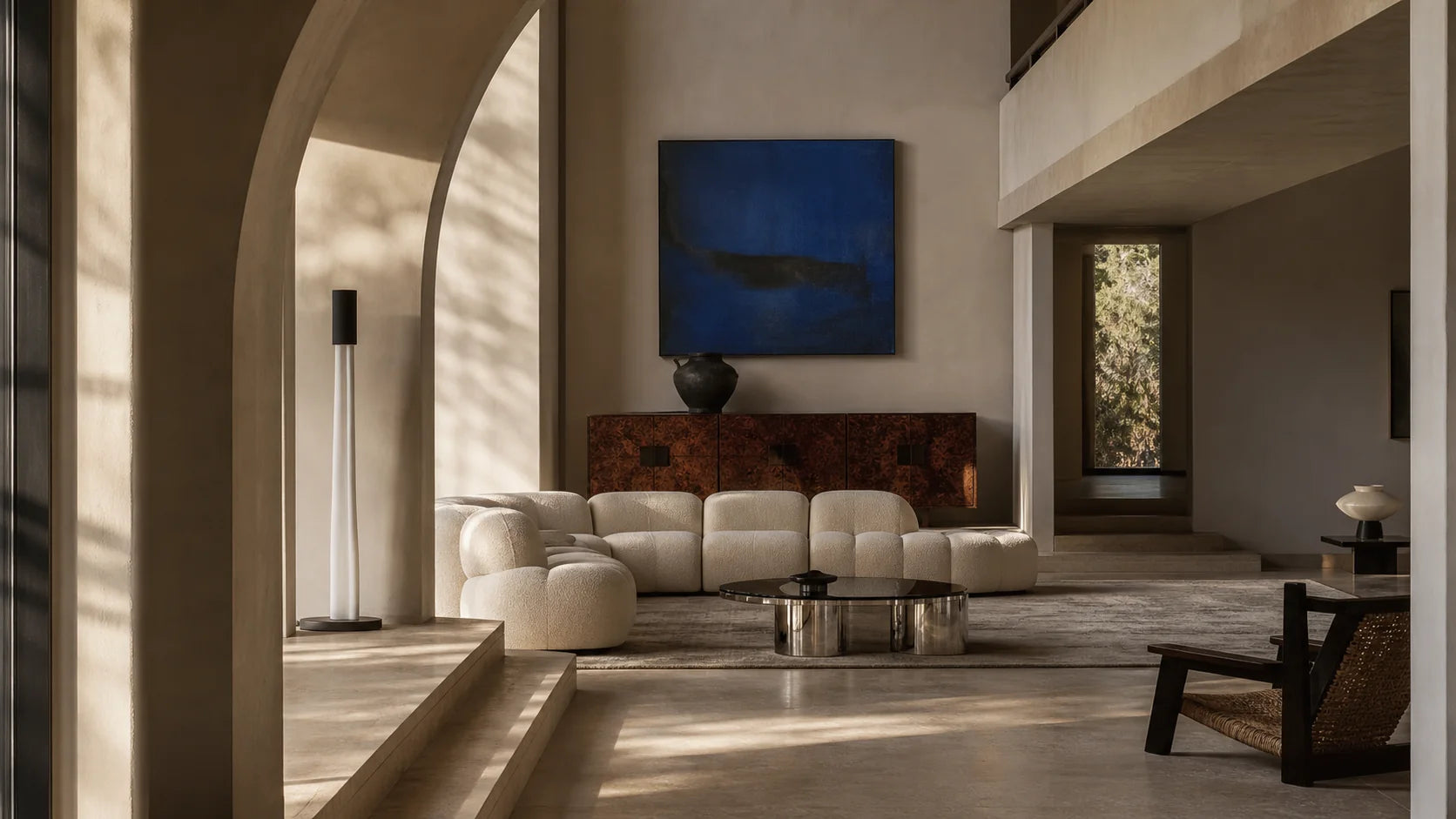 Sculptural cream seating and vintage furnishings in a warm architectural interior